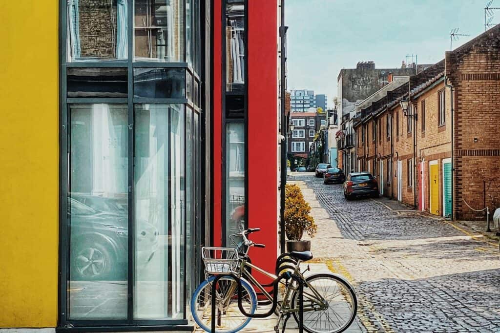 Small residential buildings with cars parked in the alley
