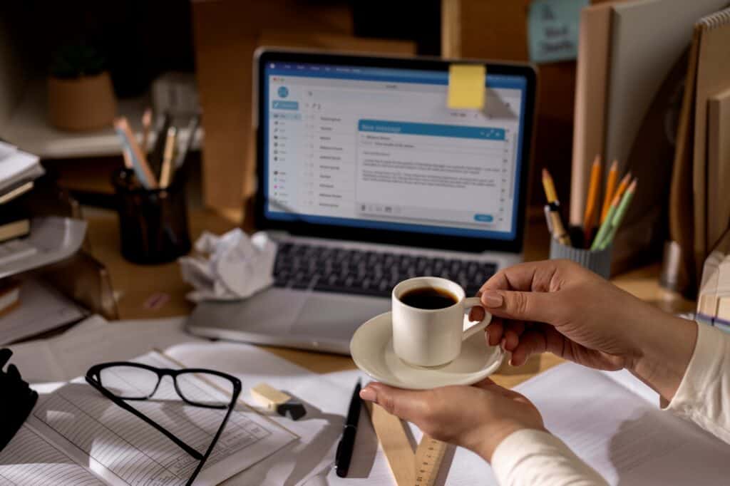 An office desk with a computer showing an email draft about the office move