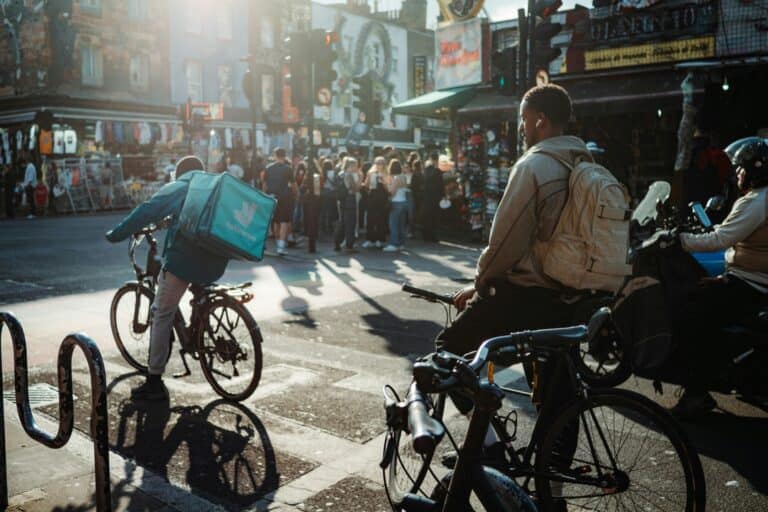 People on bikes and motorcycle on a busy road in the concept of 'how to use Streatham's public transport'.