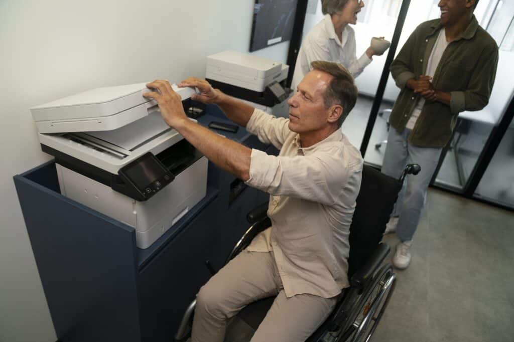 Employees in the office's copy room with printers and scanners