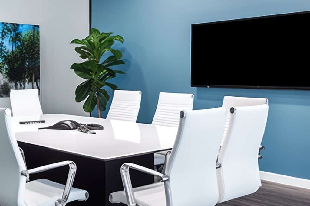 An office meeting room with a flat-screen and telephone for conferencing