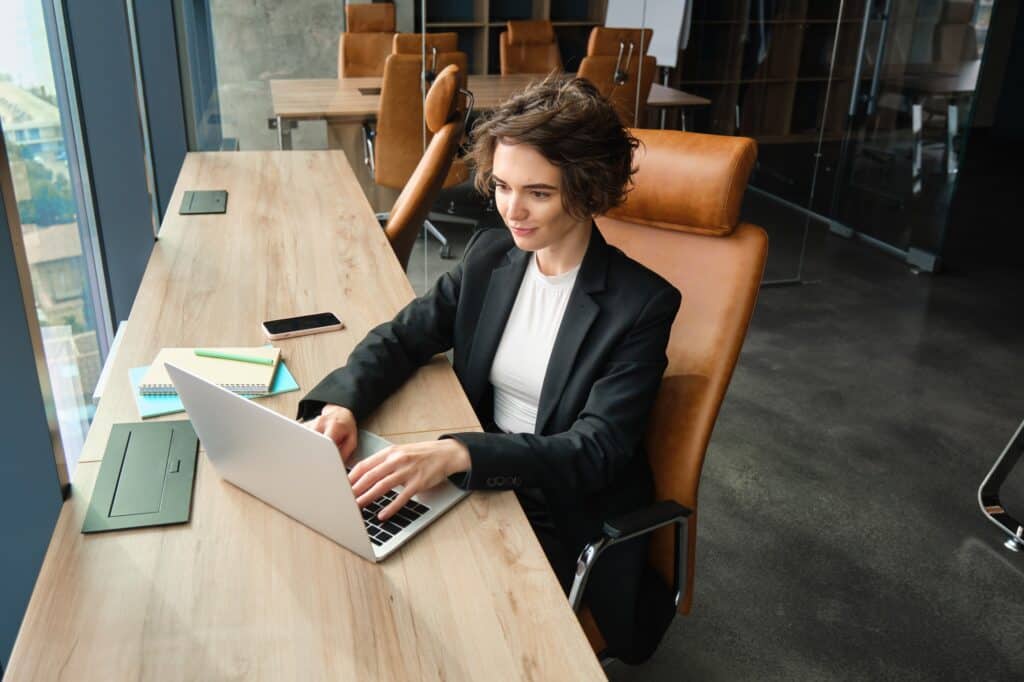A female employee researches for office removals on her laptop