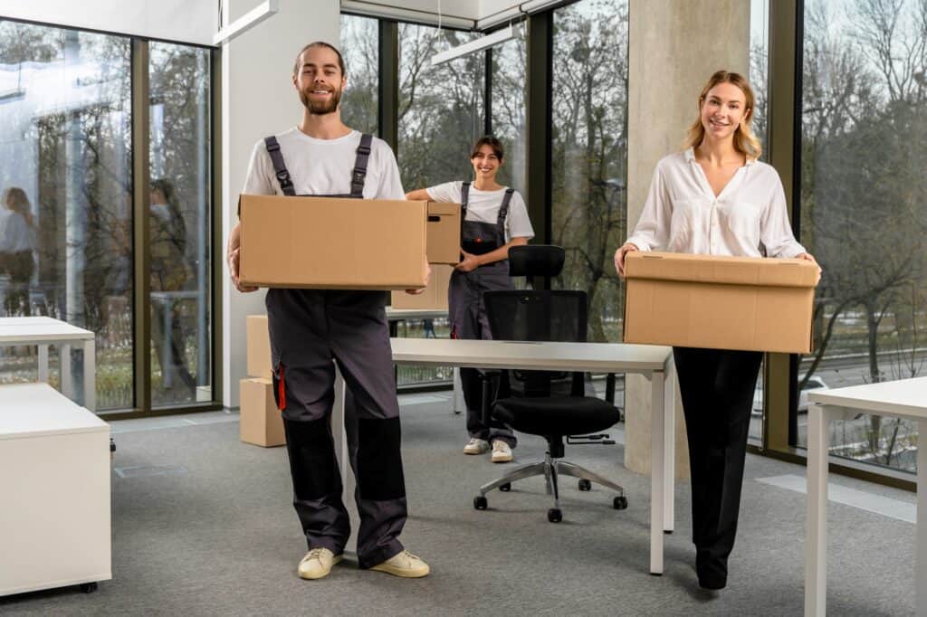 Professional office movers carrying boxes in an office in the concept of 'What Are Office Removals Services'.