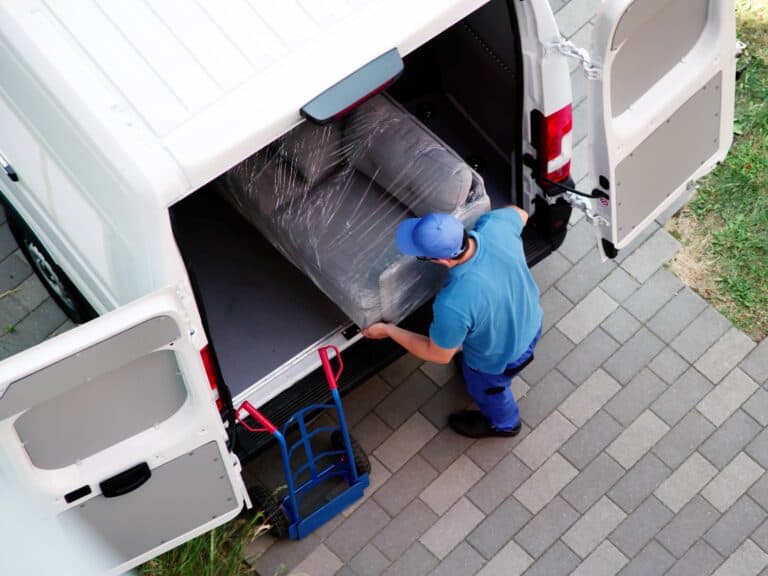 A van hire loading the couch into the van as same-day transport